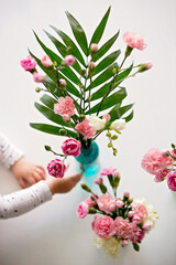 Beautiful blooming carnations in a vase on wooden background