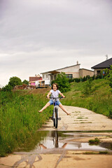 Obraz premium Child, boy, riding bike in muddy puddle, summer time