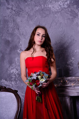 woman in red dress. woman in red dress sitting on a chair. Beautiful young woman in a red dress. New Year's decor. Christmas in a beautiful dress
