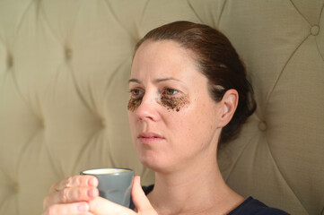 Woman relaxing at home with coffee grounds on her face