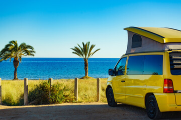 Camper van with tent on roof on beach