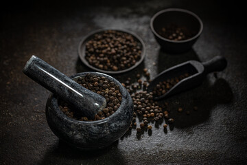 Marble mortar full of black peppercorns