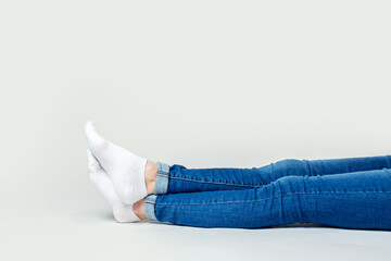 Legs of a woman sitting on the floor on a light background. Banner