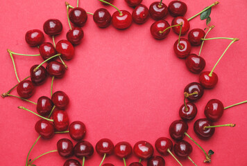 Frame made of sweet cherry on color background