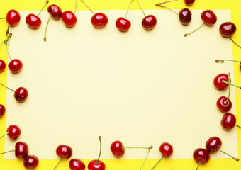 Frame made of sweet cherry on color background