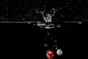 Fototapeta na wymiar Ludo dice in water splash on black background with lots of air bubbles