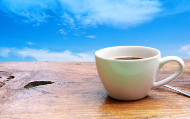 Coffee cup put on old wood table on blue sky background