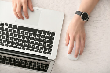 Woman using PC mouse while working on computer at table, top view