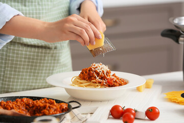 Woman cooking tasty pasta bolognese in kitchen, closeup