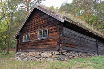 Old traditional Norwegian wooden log village house with stone fundament