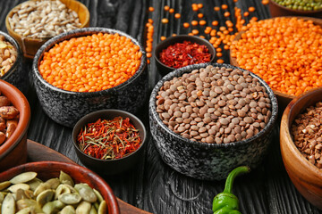 Different raw lentils with spices on table