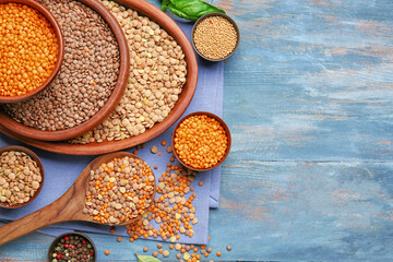 Different raw lentils with spices on table