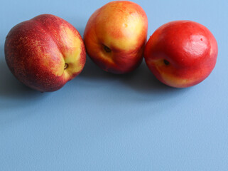 ripe nectarines on a blue background close up