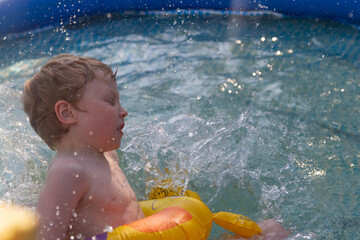 A European boy fell into the pool. The spray from the water.