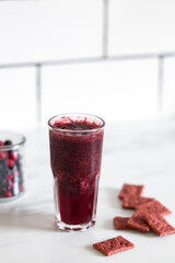Fresh healthy blueberries, cranberries and chia seeds smoothie with snack on marble background