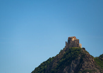 Obraz premium View of the Abbey of San Michele della Chiusa,Piedmont, Italy. Footage from the mountain on the opposite side of the valley, this abbey perched at the top of the peak has an imposing appearance.