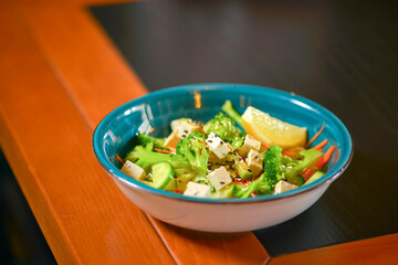 Classic vegetable salad from tomatoes, cucumbers, lemon, red pepper, onion, brocolli, oregano and feta cheese.