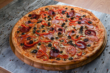 Flat lay photograph of tasty italian pizza on rustic wood. Pepperoni, cheese and peppers. Delicious food.