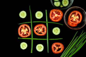 Diet concept hazardous game for health tic tac toe made of tomatoes cucumbers and green onion
