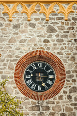 Old clock on the wall,  Gothic clock tower in the square of the medieval city