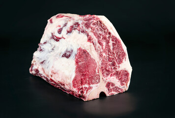 Rohes dry aged Wagyu Porterhouse Block von Rind angeboten als close-up auf schwarzen Hintergrund...