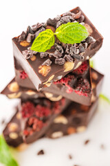 Chocolate with nuts and raspberries and fresh mint leaves.