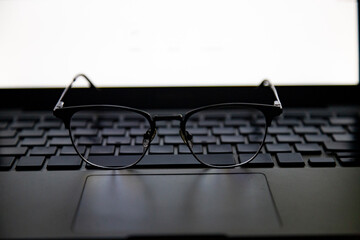 Close up view of a glasses on the laptop's keyboard
