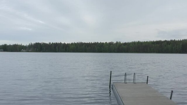 Empty pier on a lake surrounded forest.