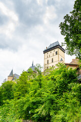 Famous medieval gothic castle Karlstejn on top of the hill. Beautiful stronghold is built by king Charles IV. Historical national heritage of Czech Republic is placed near Prague city. Cloudy weather
