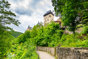 Famous medieval gothic castle Karlstejn on top of the hill. Beautiful stronghold is built by king Charles IV. Historical national heritage of Czech Republic is placed near Prague city. Cloudy weather