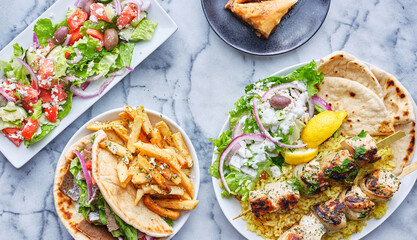 greek meal with chicken souvlaki platter, gryos, french fries, salad and baklava