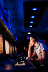 Puzzled gamer looking at computer monitor at internet cafe, portrait.
