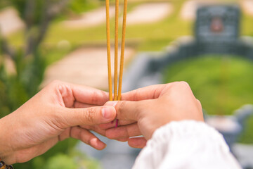 close-up of a woman hand holding incense. Concept of spiritual and religious