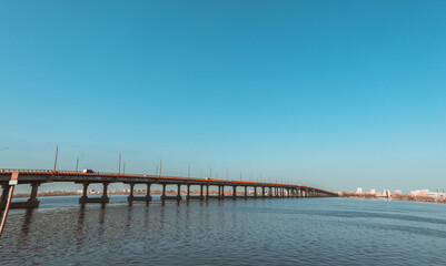 Fototapeta premium Long bridge over the river on a sunny summer day.
