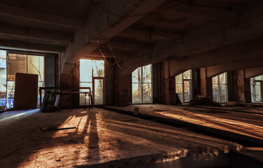 The sun's rays break through the abandoned windows in an empty building.