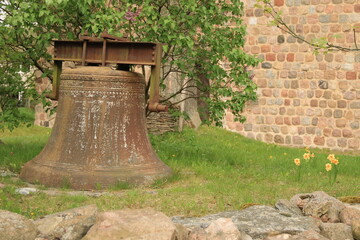 große alte Glocke aus Eisen vor einer Kirche