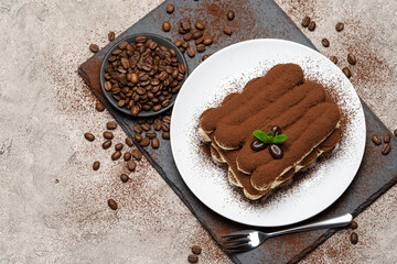 Classic tiramisu dessert on ceramic plate on concrete background
