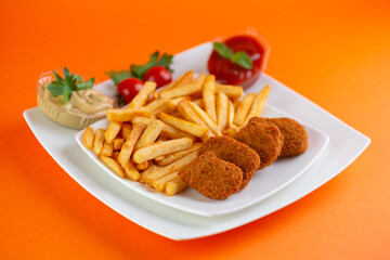 Fried chicken nuggets with fries and tomato ketchup.