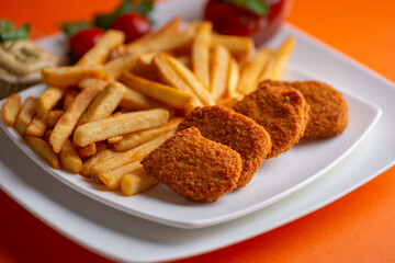 Fried chicken nuggets with fries and tomato ketchup.