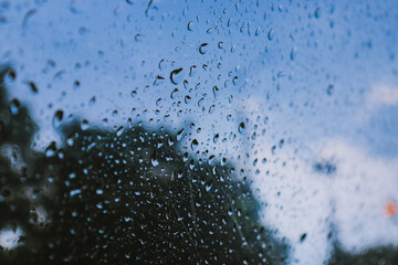 Drops of summer rain on a car window on a cloudy day.