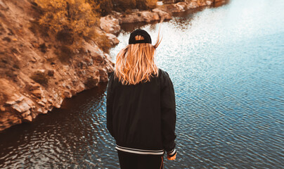 Girl on the edge of a cliff with a river below.