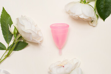 Flat lay composition with menstrual cup and white flowers on light background, space for text. Gynecological care
