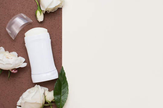 Flat lay composition with deodorant and flowers on color background, copy space