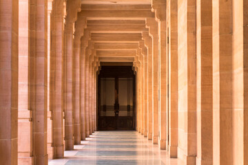 Sand stone corridor with pillars leading to a door. Rajasthan , india Umedbhawan