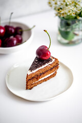 chocolate cake with cherry on white table