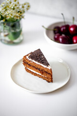 chocolate cake with cherry on white table