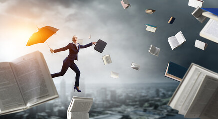 Young businesswoman walking with umbrella