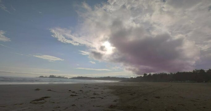 Lockdown time lapse shot of people at beach against cloudy sky during sunset - Tofino, Canada