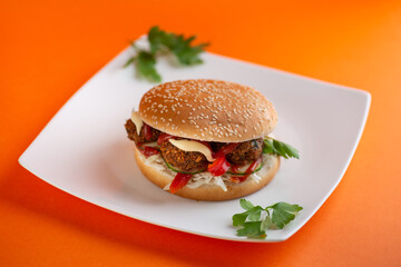 Falafel vegetarian burger with vegetables isolated on white plate