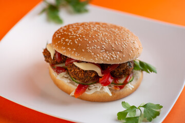 Falafel vegetarian burger with vegetables isolated on white plate